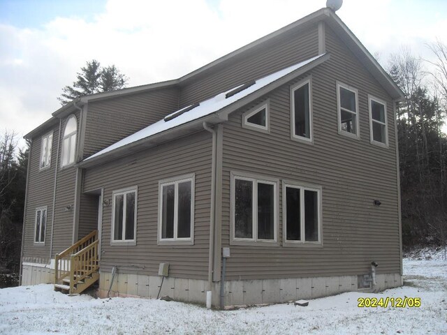 view of snow covered back of property