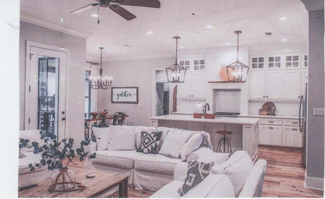 living room featuring ceiling fan, light wood-type flooring, and sink