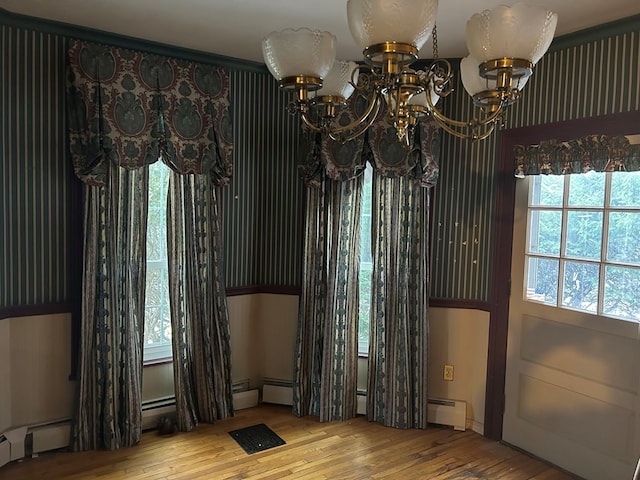 interior space featuring a baseboard heating unit, a notable chandelier, and light hardwood / wood-style floors