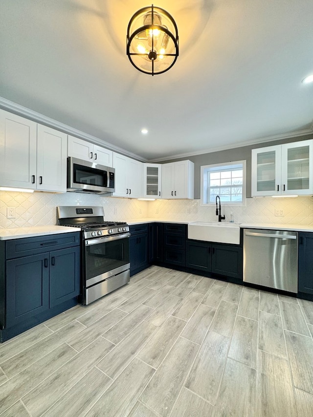 kitchen with stainless steel appliances, white cabinetry, sink, and tasteful backsplash