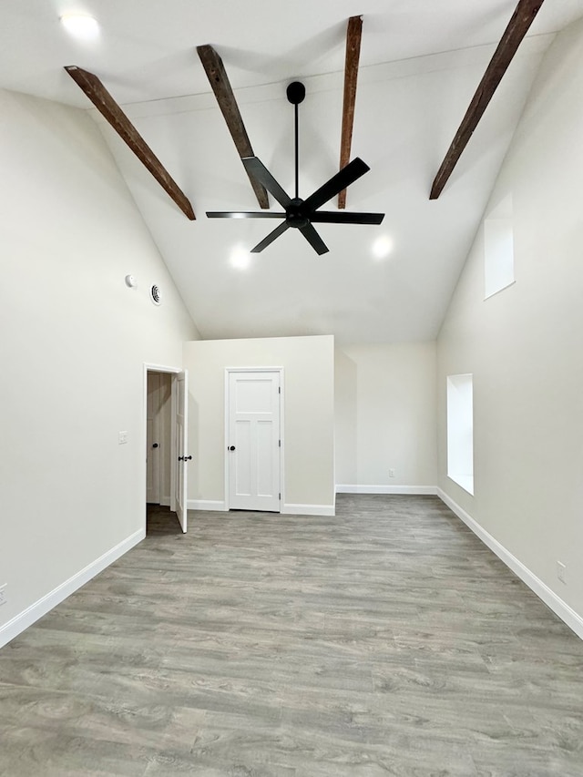 unfurnished room with beam ceiling, light hardwood / wood-style flooring, high vaulted ceiling, and ceiling fan