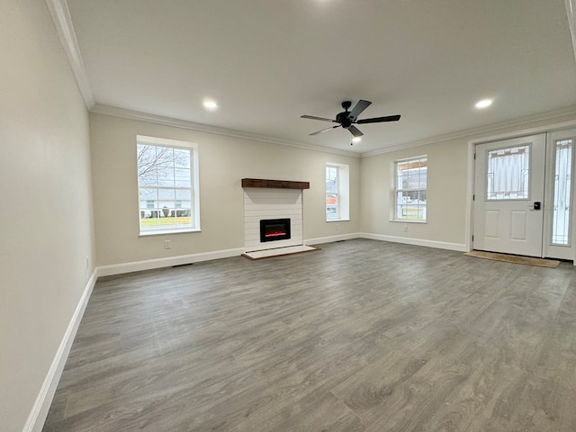 unfurnished living room featuring ornamental molding, a brick fireplace, hardwood / wood-style floors, and ceiling fan