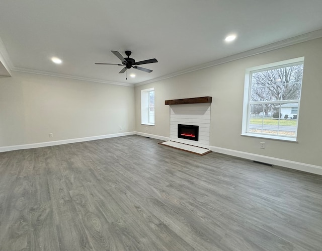 unfurnished living room with wood-type flooring, ceiling fan, and crown molding