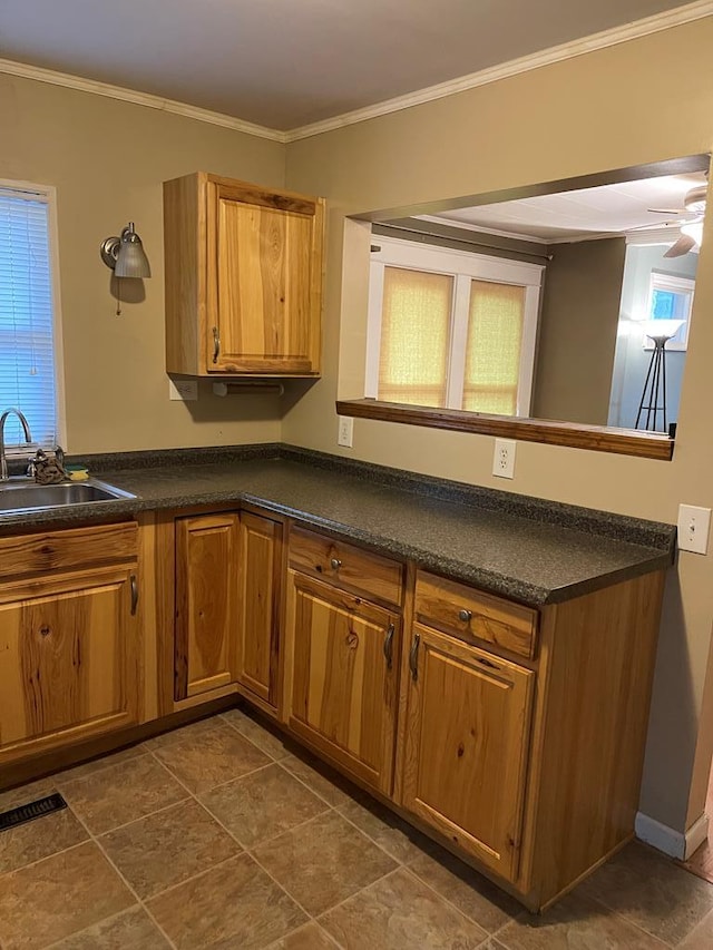 kitchen with kitchen peninsula, ceiling fan, crown molding, and sink