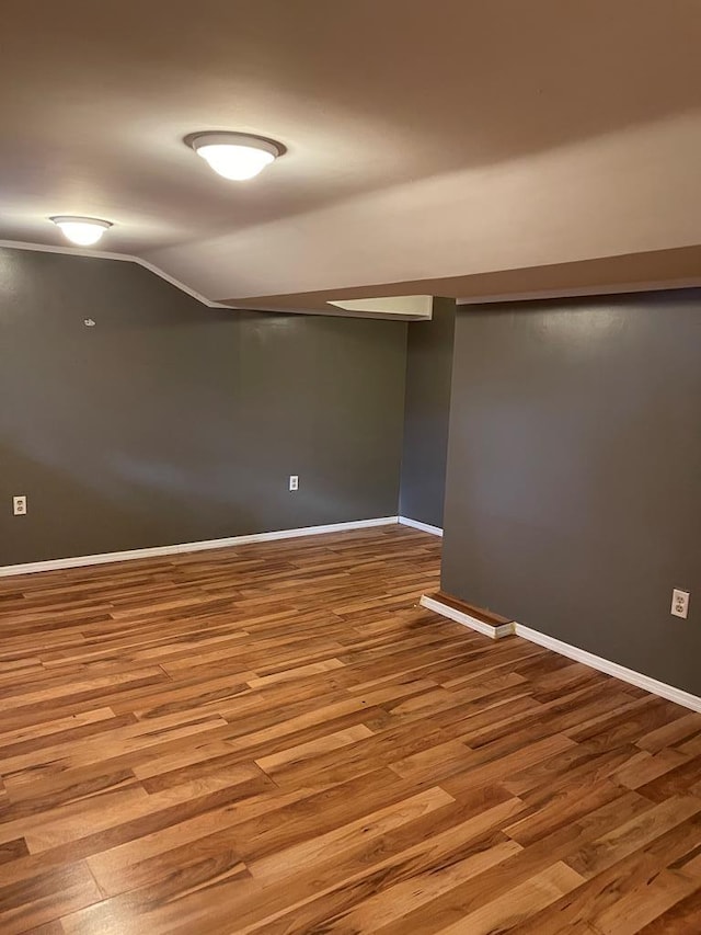 empty room featuring hardwood / wood-style flooring and lofted ceiling