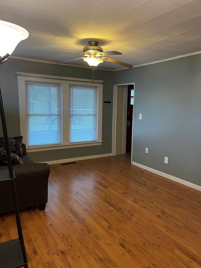 interior space with hardwood / wood-style floors, ceiling fan, and crown molding