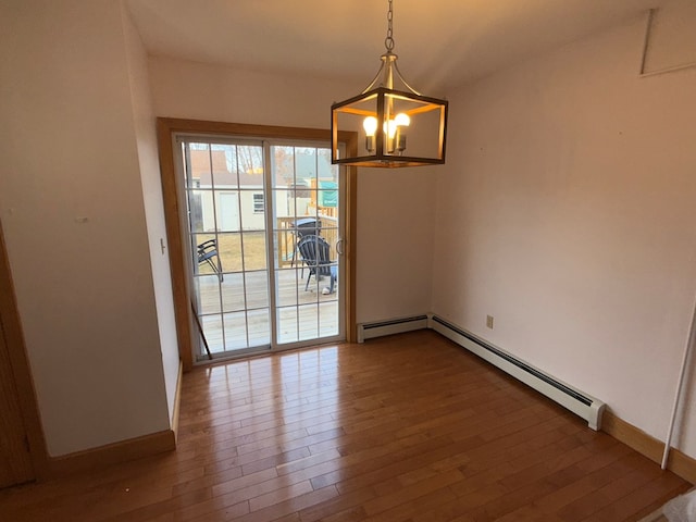 unfurnished dining area with wood-type flooring, baseboard heating, and a notable chandelier