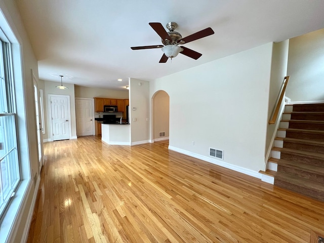 unfurnished living room featuring ceiling fan and light wood-type flooring