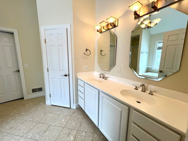 bathroom featuring vanity, a notable chandelier, and a bathtub