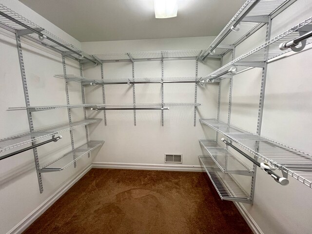 spacious closet featuring dark carpet