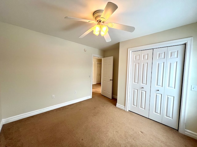 unfurnished bedroom with light colored carpet, ceiling fan, and a closet