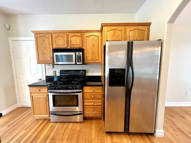 kitchen featuring appliances with stainless steel finishes and light hardwood / wood-style flooring