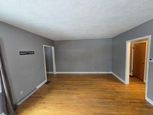 empty room with a textured ceiling and light wood-type flooring