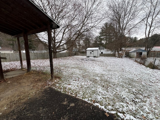 yard layered in snow featuring a storage shed