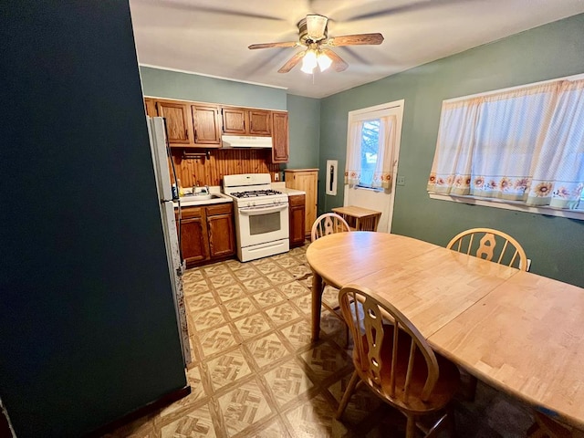 kitchen with ceiling fan, white range with gas stovetop, and sink