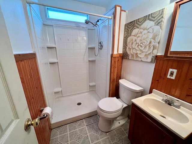 bathroom with vanity, toilet, a shower, and wooden walls