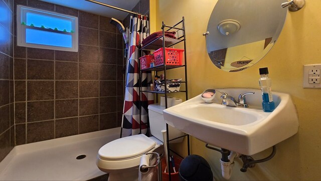 bathroom with a shower with shower curtain and toilet