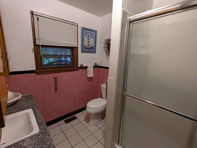 bathroom with vanity, tile patterned floors, toilet, tile walls, and an enclosed shower