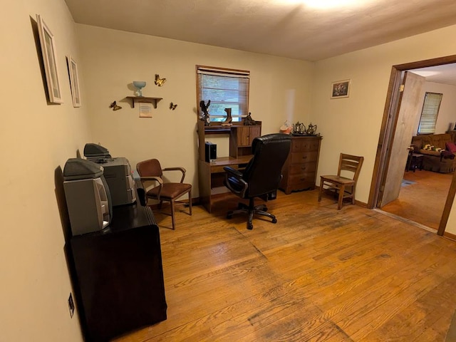 home office with light hardwood / wood-style floors