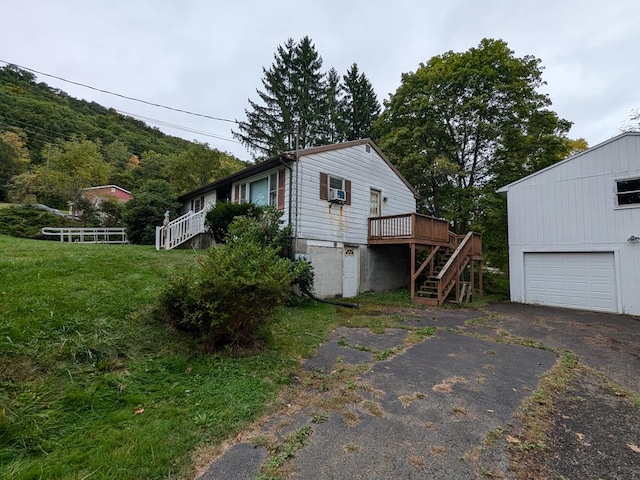 view of side of property featuring a yard, a garage, and a wooden deck