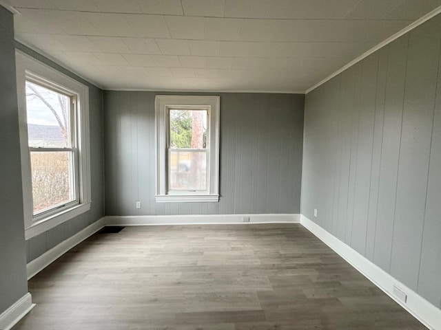 unfurnished room with hardwood / wood-style flooring, a healthy amount of sunlight, and ornamental molding