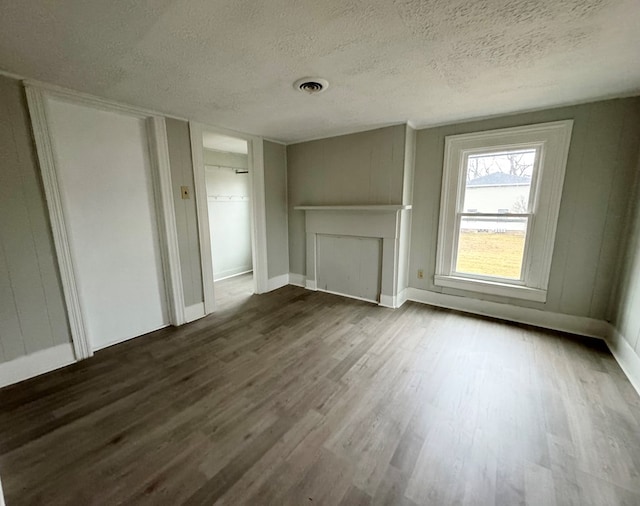 unfurnished living room featuring dark hardwood / wood-style flooring and a textured ceiling