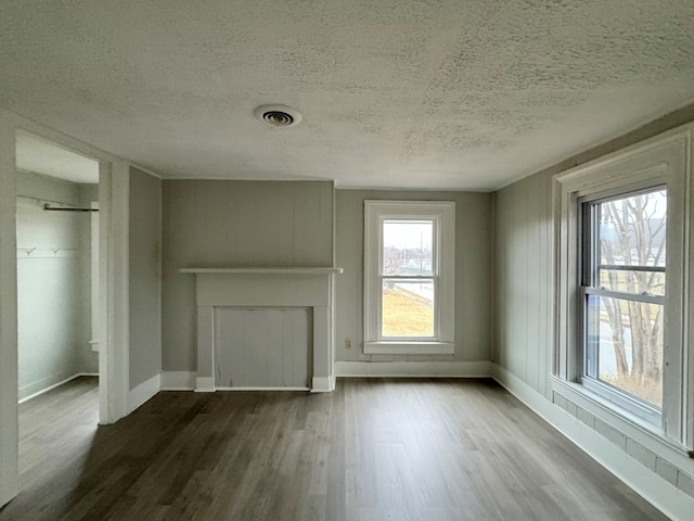 unfurnished living room with hardwood / wood-style floors and a textured ceiling