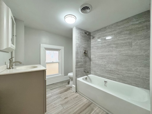 full bathroom featuring wood-type flooring, vanity, toilet, and  shower combination