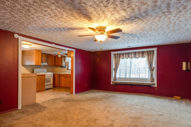 interior space featuring light colored carpet, ventilation hood, ceiling fan, white range, and a textured ceiling