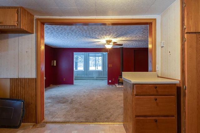 interior space with light colored carpet, ceiling fan, and a baseboard radiator