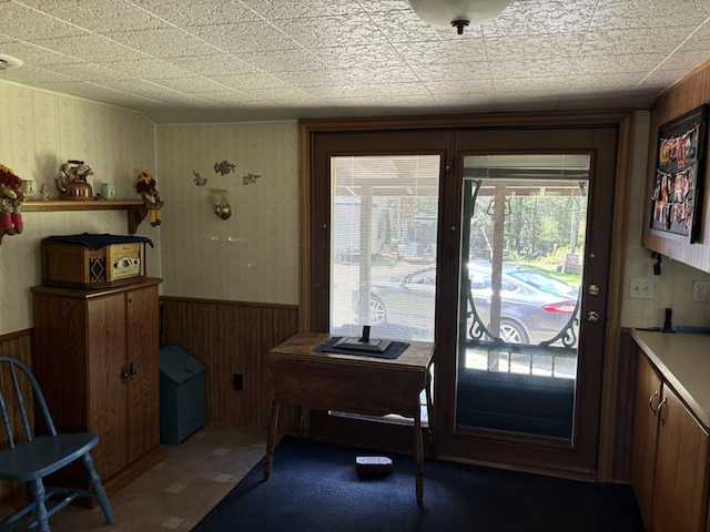 doorway to outside with wood walls