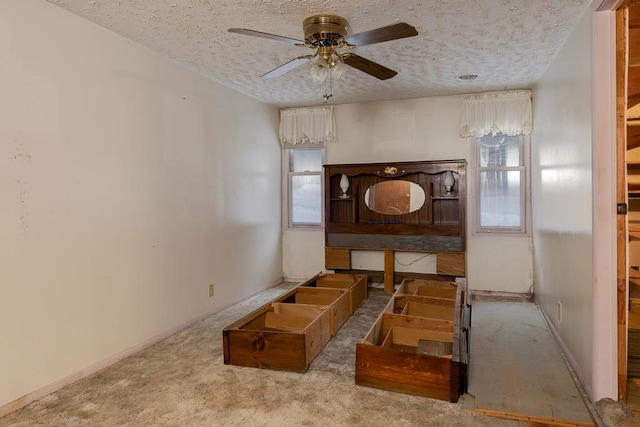 interior space featuring a textured ceiling, ceiling fan, and light colored carpet