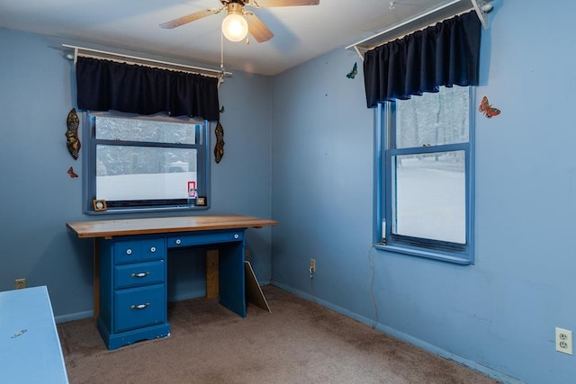 unfurnished office with ceiling fan, a wealth of natural light, and light carpet