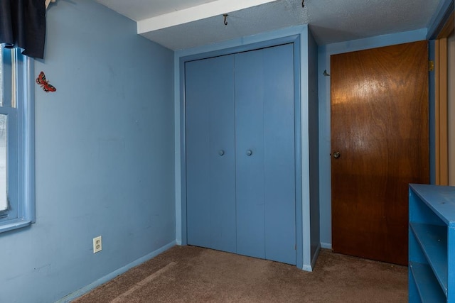 unfurnished bedroom with a closet, light carpet, and a textured ceiling