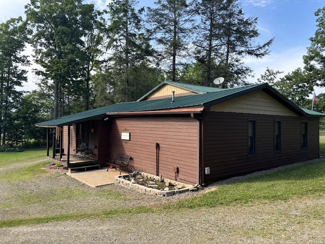 view of property exterior featuring a patio and a lawn