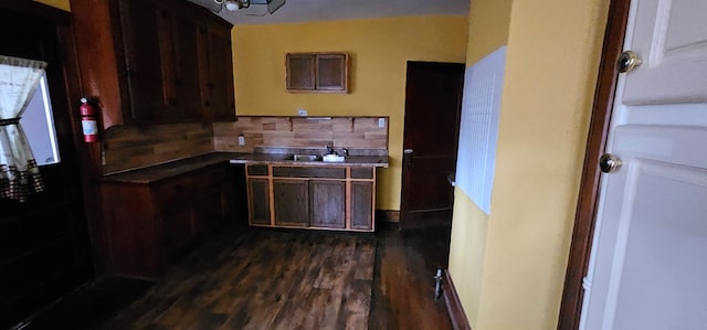 kitchen with dark hardwood / wood-style flooring, sink, dark brown cabinets, and backsplash