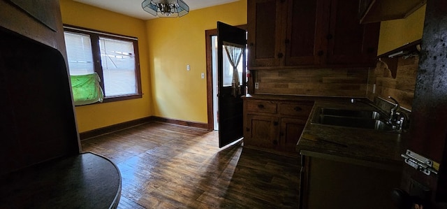 kitchen with dark hardwood / wood-style flooring, sink, and a chandelier