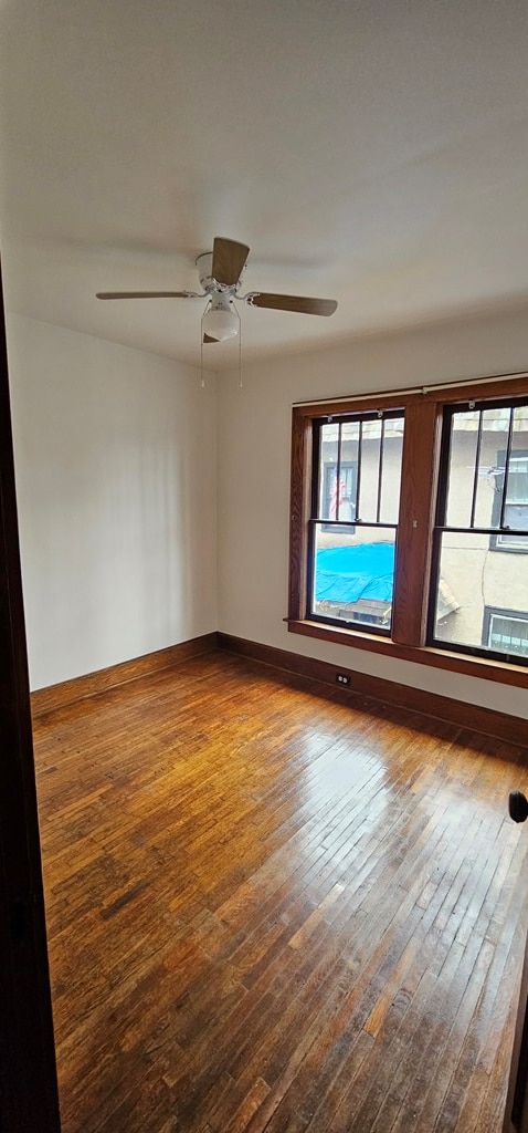 unfurnished room with hardwood / wood-style flooring and ceiling fan