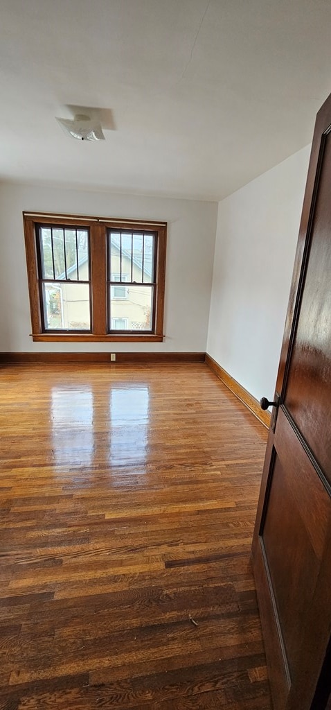 unfurnished room with wood-type flooring