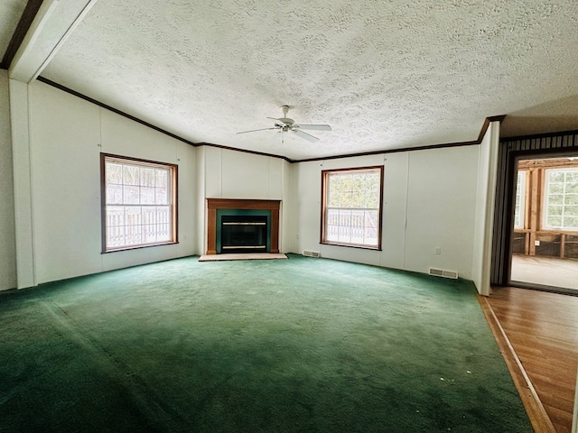 unfurnished living room featuring a textured ceiling, carpet floors, ceiling fan, and lofted ceiling