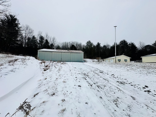 yard layered in snow featuring an outbuilding