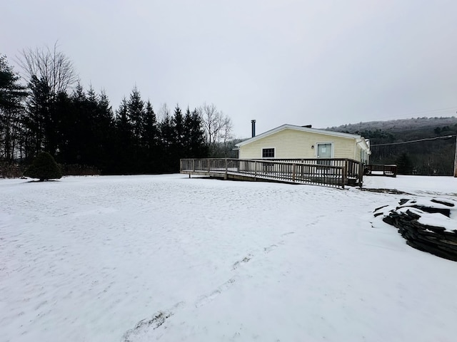 snowy yard featuring a wooden deck