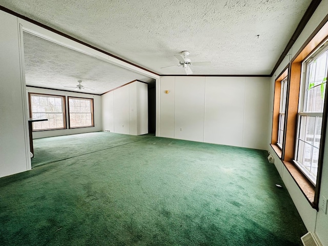 spare room with carpet flooring, a textured ceiling, ceiling fan, crown molding, and lofted ceiling