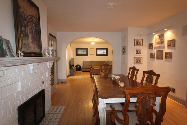 dining space with a fireplace and light hardwood / wood-style flooring