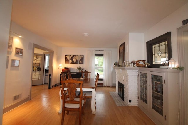 dining area featuring a fireplace and light hardwood / wood-style floors