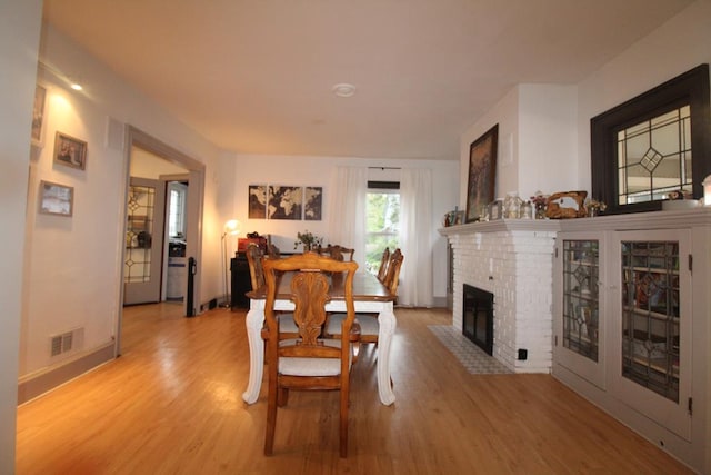 dining area featuring a fireplace and light hardwood / wood-style flooring