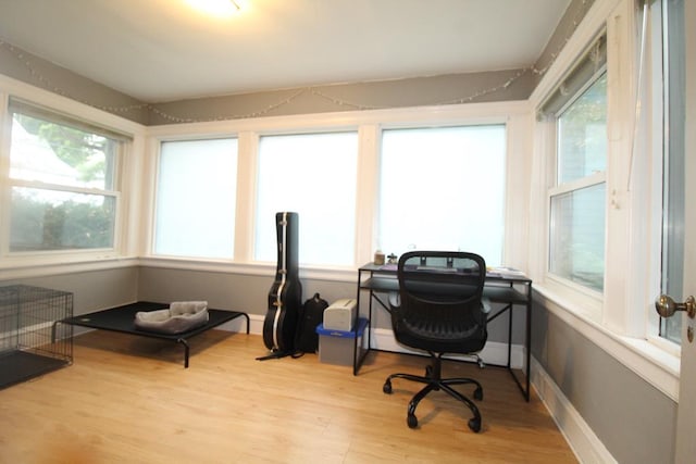 home office with light hardwood / wood-style flooring