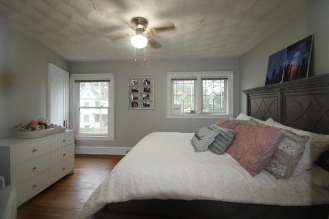 bedroom with hardwood / wood-style floors, ceiling fan, and multiple windows