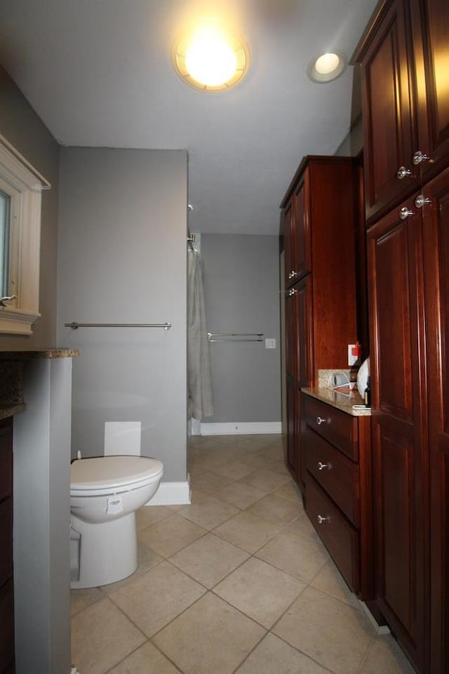 bathroom featuring walk in shower, tile patterned flooring, and toilet