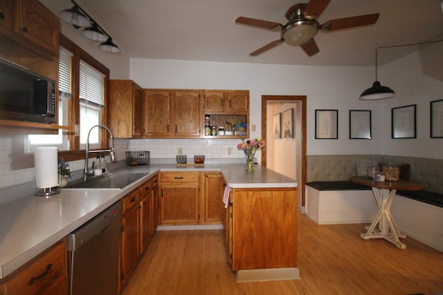 kitchen with pendant lighting, backsplash, stainless steel dishwasher, and sink